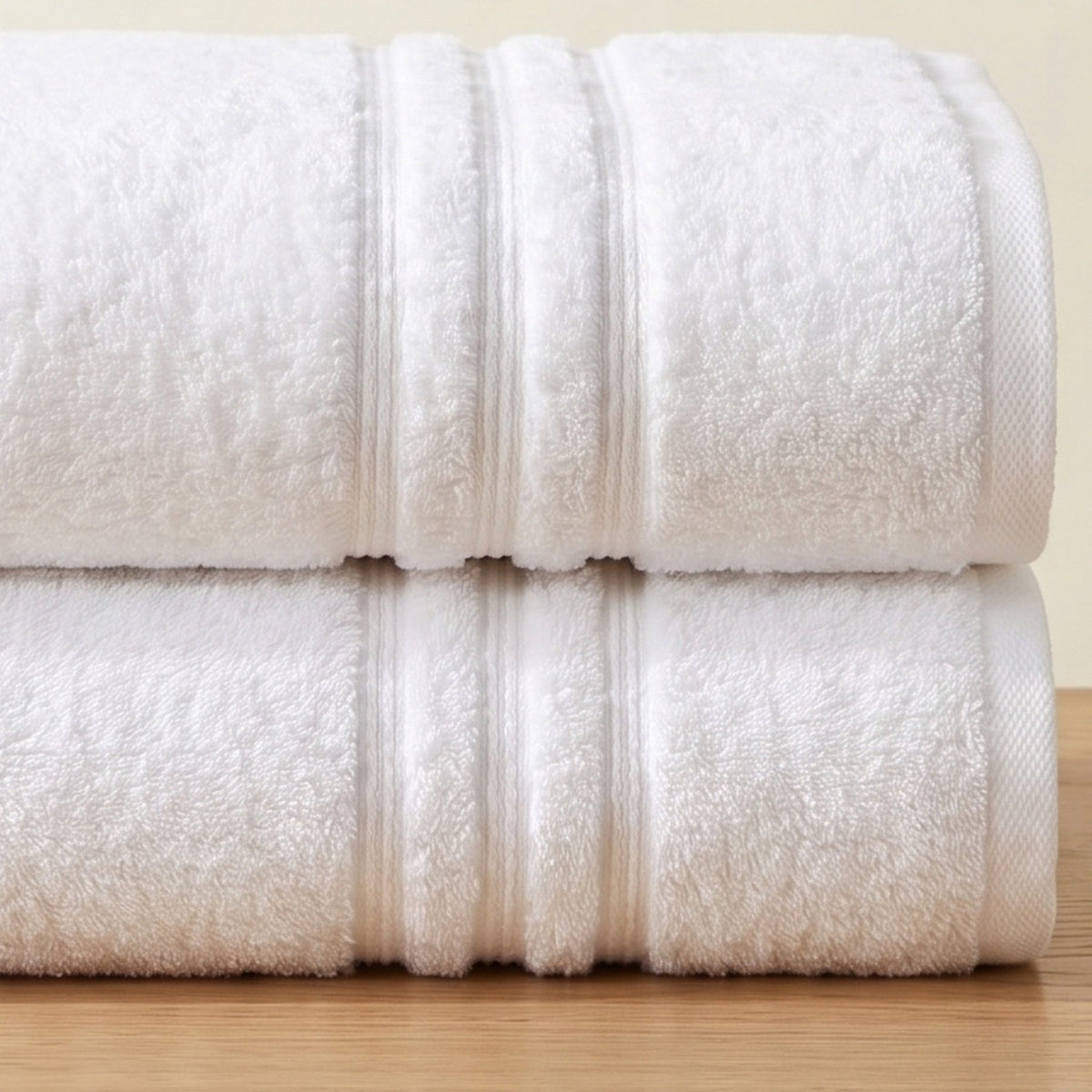 Three raised cords on the border of a white MIORA bath towel, close up